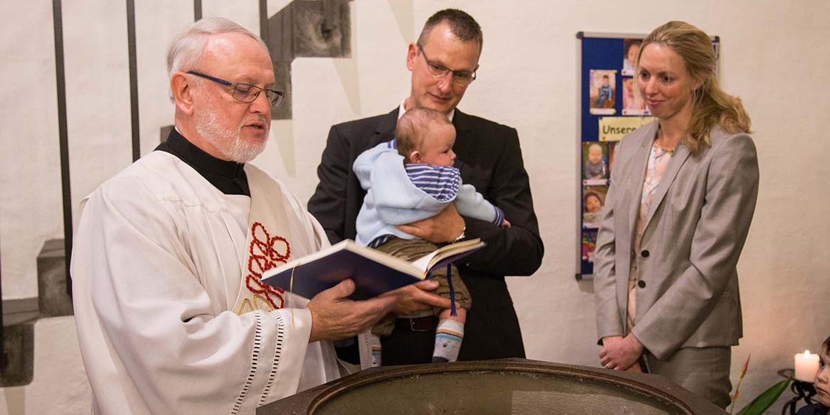 Diakon Winfried Reers tauft ein Kind in Rheinbreitbach.