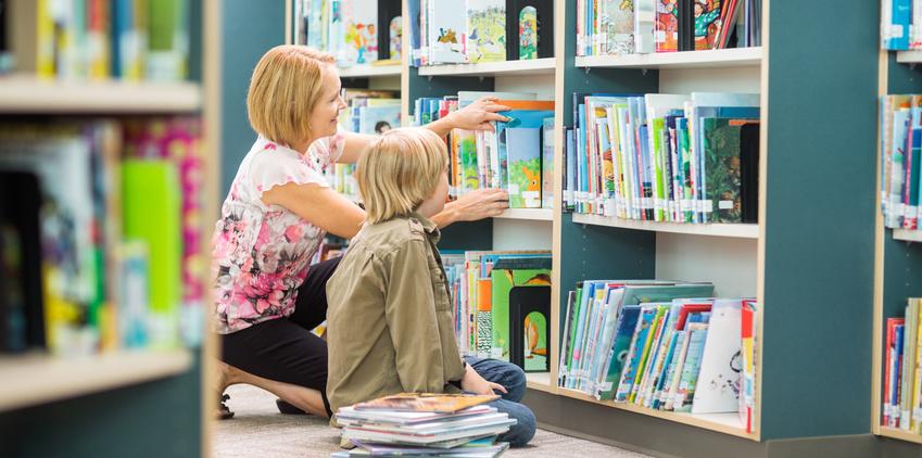 Frau mit Kind am Bücherregal