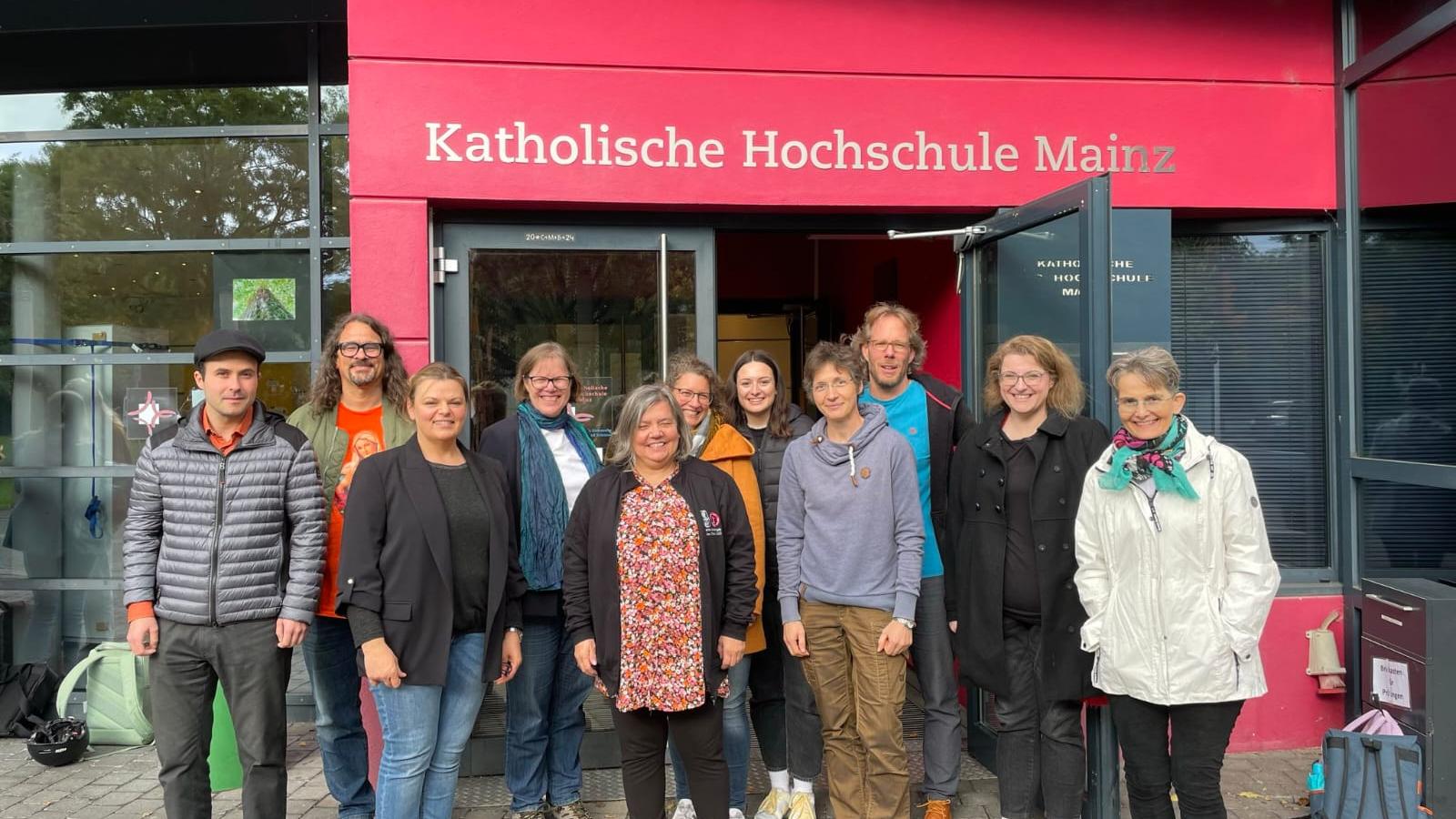 Gruppenfoto der 11 Erstsemester der Praktischen Theologie in Teilzeit vor dem Haupteingang der KH Mainz