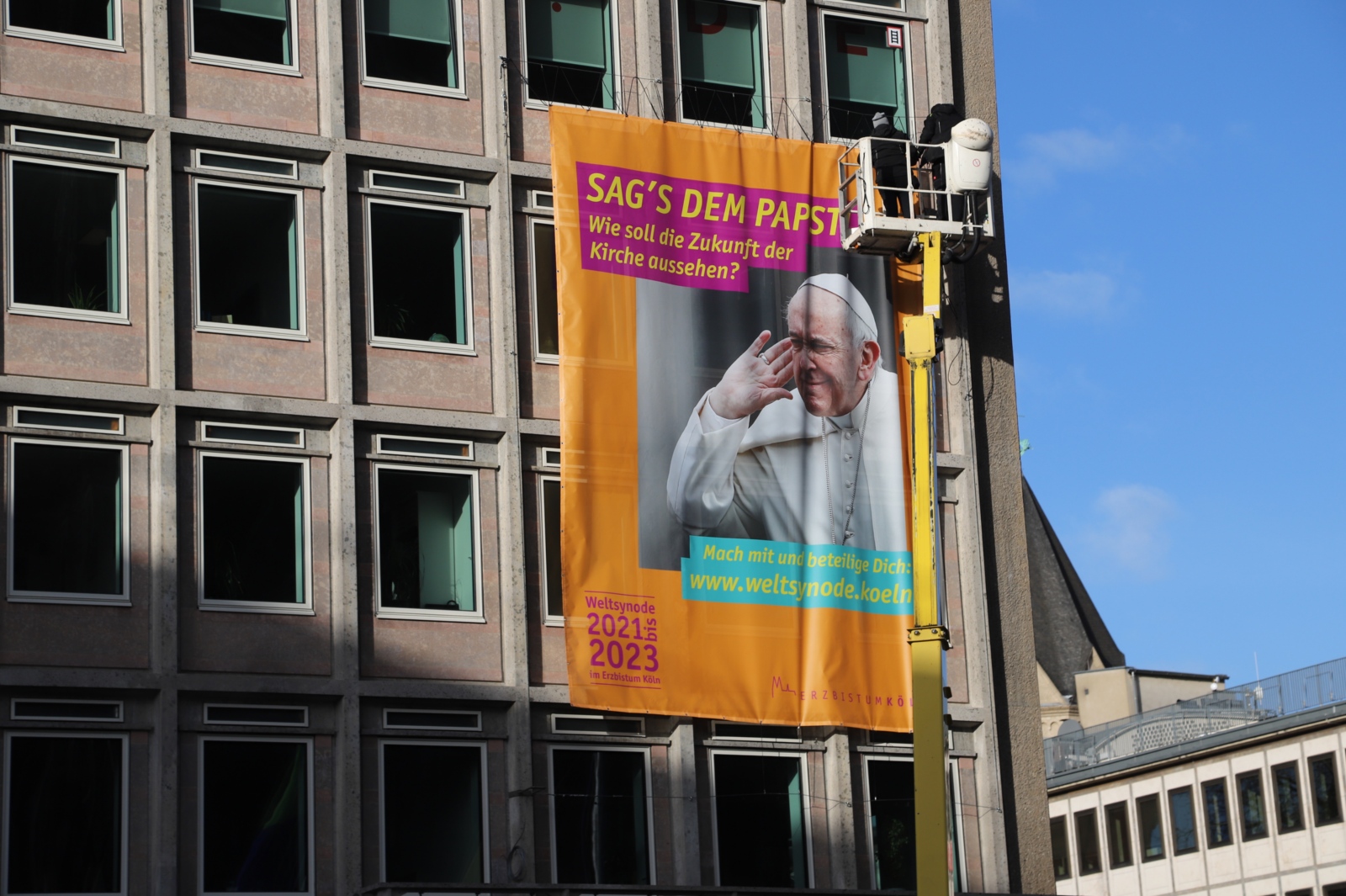 Montage des Plakats zur Weltsynode 2021-2023